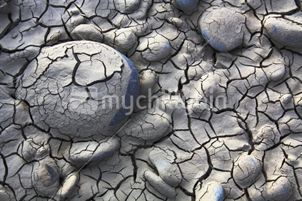 Dried out clay/ sand with pebbles at a Canterbury river mouth opens up to create these cracks and fissures.