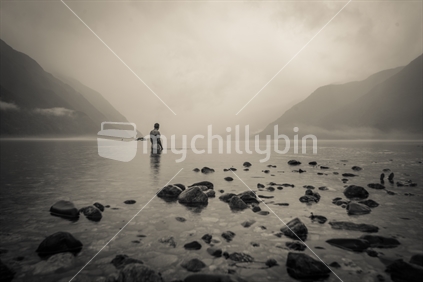 Man standing in the lake amid the mist