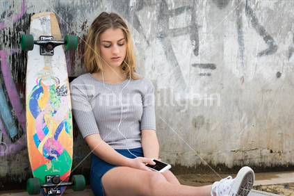 Teenage skater girl listening to music