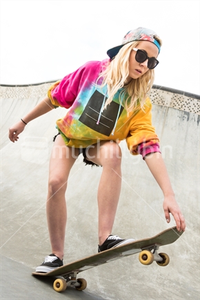 Blond girl skateboarding in bowl