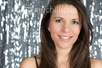 Beautiful smiling woman against silver background