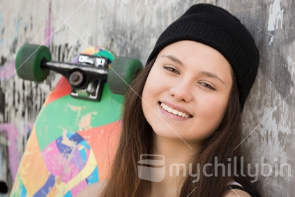 Maori teenage girl smiling with skateboard