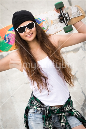 Pretty Maori skater girl holding skateboard