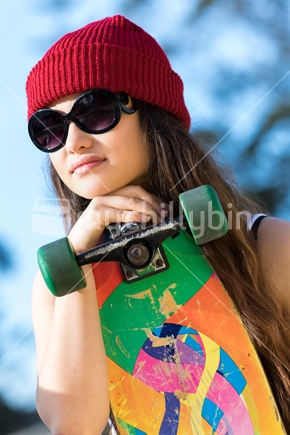 Pretty teenage Maori girl with skateboard