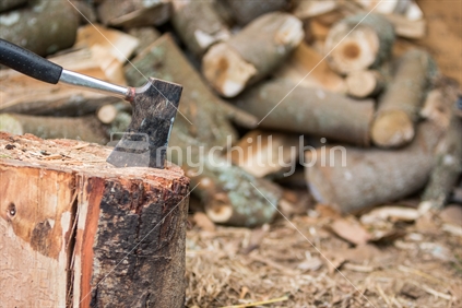 Hatchet axe in stump with firewood