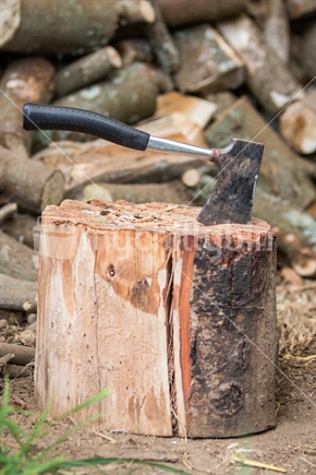 Hatchet axe in stump with firewood