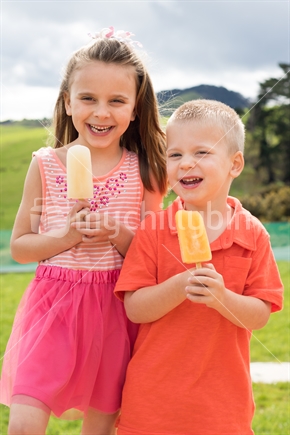Two children eating ice blocks