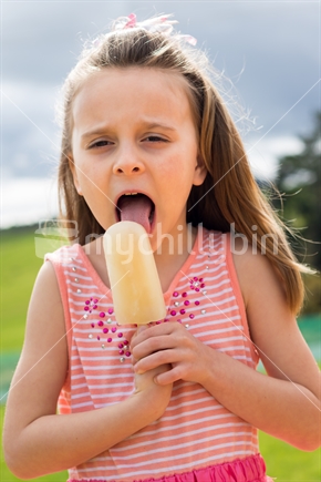Pretty little girl eating ice block