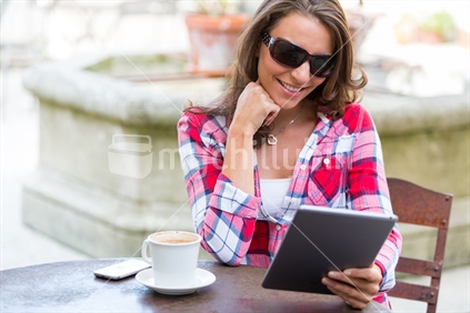 Beautiful woman at cafe using tablet