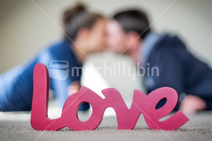 Couple kissing with love wooden block