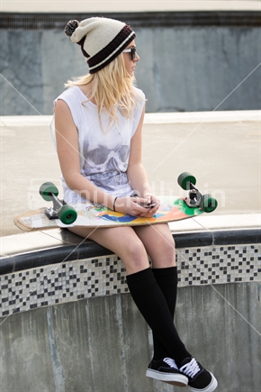 Blond skater girl holding skateboard