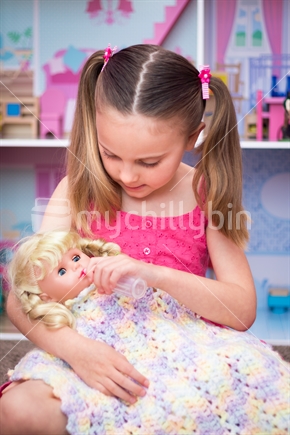 Pretty girl playing with baby doll