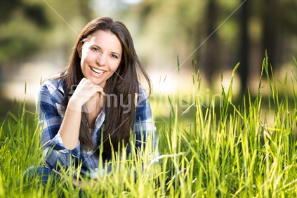 Beautiful laughing woman sitting in grass