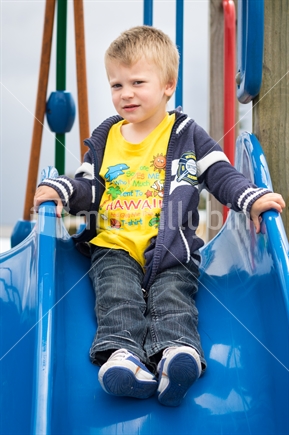 Little boy on playground slide
