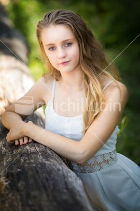 Pretty teenage girl next to log