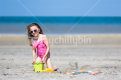 Little girl playing in the sand at beach