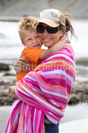 Mother holding little boy at the beach