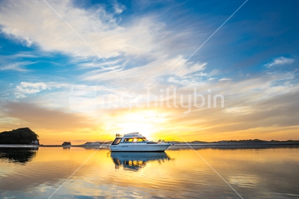 Boat anchored in the harbour at sunrise in Mangawhai Heads