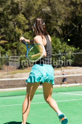 Female tennis playing hitting the ball