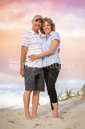 Middle aged couple on the beach at sunset