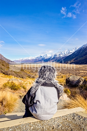 Young boy sitting on track step looking at view
