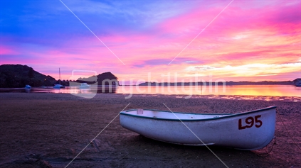 Pink sunrise with dinghy in foreground