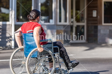 Woman in wheelchair in front of medical centre