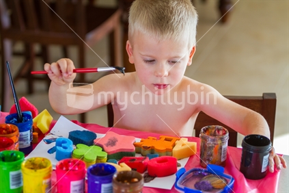 Little boy playing with paint