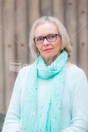 A portrait shot of a good looking blonde woman in glasses.