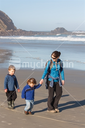 Family walking on Sandfly Bay Beach in Dunedin - exploring the line in the sand