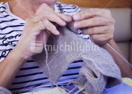 Close up of woman's hands knitting with wool (motion blur)