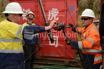 Well engineers remove tools from the end of concrete pumping equipment while abandoning an 850m deep oil well near Moana.