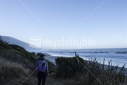 Girl tramping The Heaphy Track at dawn
