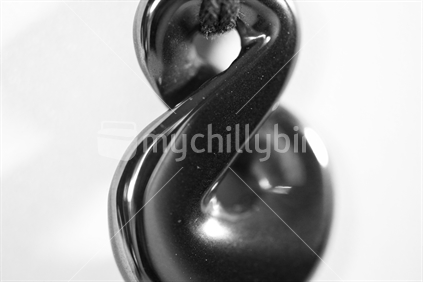 Black and white of a glass pendant of a pikorua (small twist).