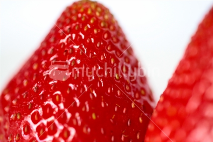A close up of the skin and the end of a strawberry.