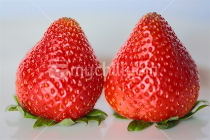 Two strawberries upside down.