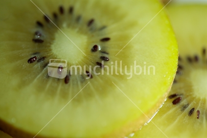 Close up of gold kiwi fruit slices.  With the skin of the fruit showing.