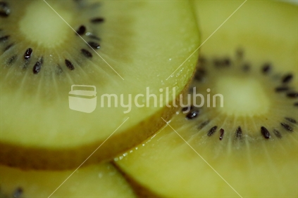 Slices of a gold kiwi fruit.
