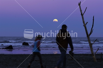 Partial eclipse beach walk 2021 at sunset and moon rise.